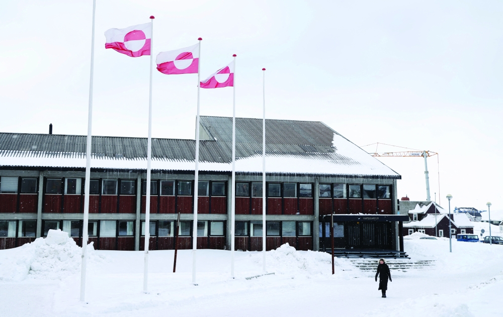 A woman walks past Greenland's parliament Inatsisartut in Nuuk, Greenland. — Reuters