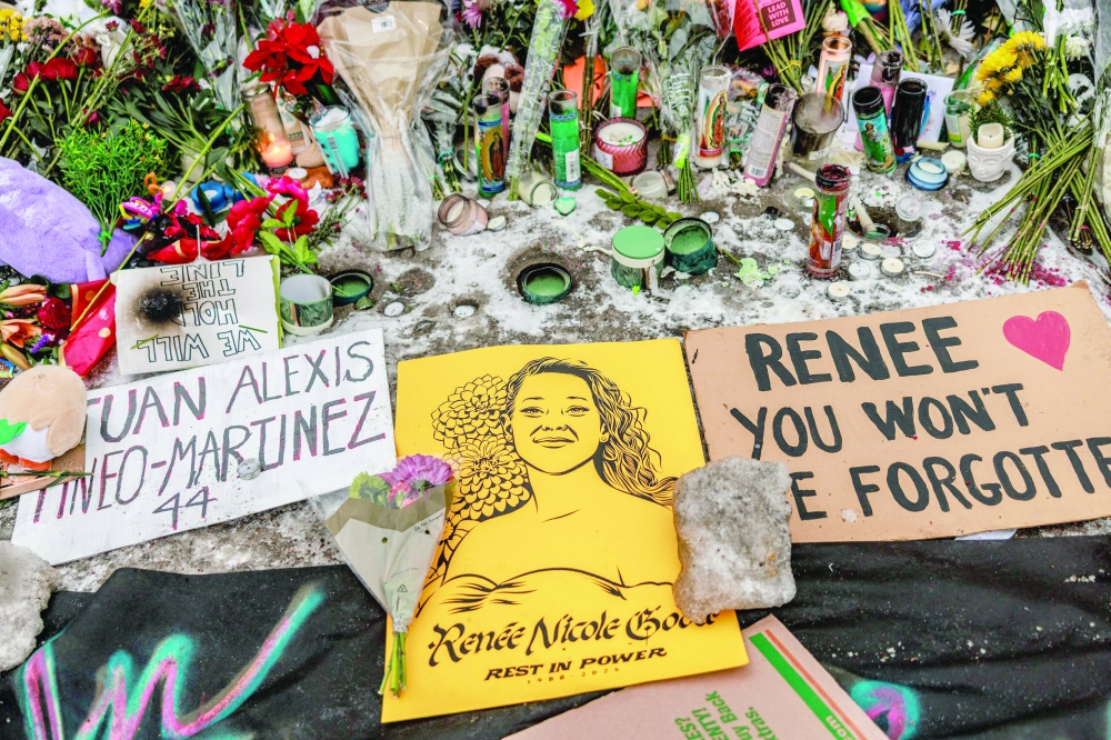 Candles, flowers and signs are placed at a makeshift memorial honoring Renee Nicole Good, in Minneapolis. — AFP