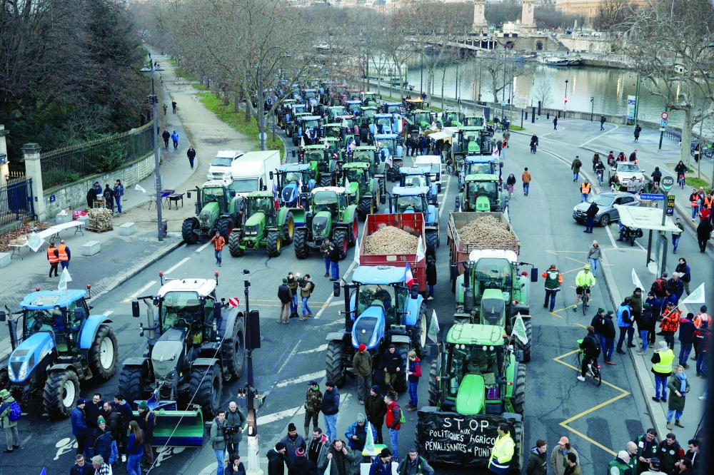 Tractors are parked along the Seine river as farmers protest, in Paris. — AFP
