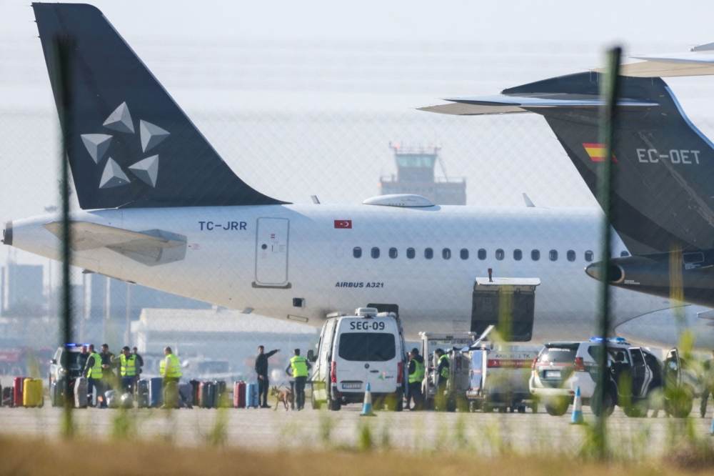 Security and airport officials are seen at a secure area on the tarmac after Turkish Airlines flight TK1853