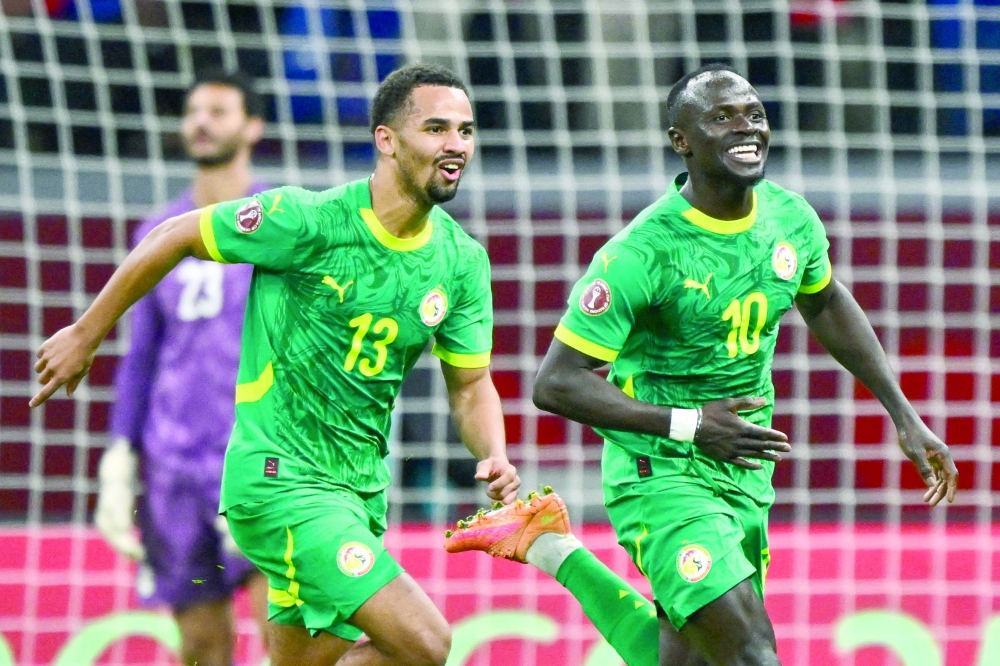 Senegal's Sadio Mane celebrates his goal with Iliman Ndiaye during the Africa Cup of Nations (CAN) semi-final football match between Senegal and Egypt at the Grand stadium in Tangiers on January 14, 2026.   (Photo by SEBASTIEN BOZON / AFP)