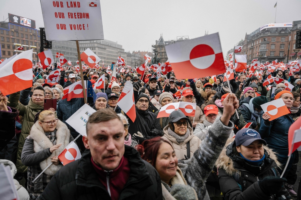 Protesters wave Greenlandic flags as they take part in a rally under the slogans 'hands off Greenland' 