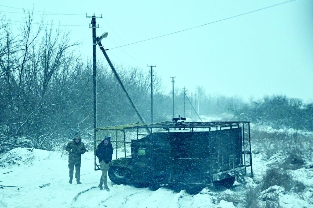 Ukrainian servicemen walk next to a Humvee near a front line, in Zaporizhzhia region. — Reuters