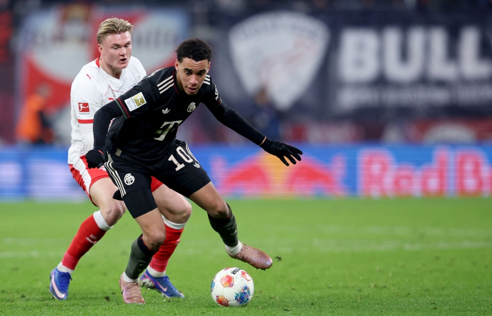 Bayern Munich's German midfielder #10 Jamal Musiala (R) and Leipzig's Danish forward #11 Conrad Harder vie for the ball 