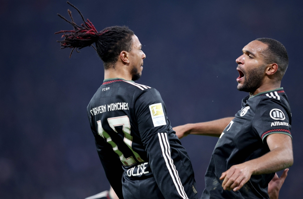 Bayern Munich's Jonathan (R) celebrates with  Michael Olise after scoring the 1-3 goal