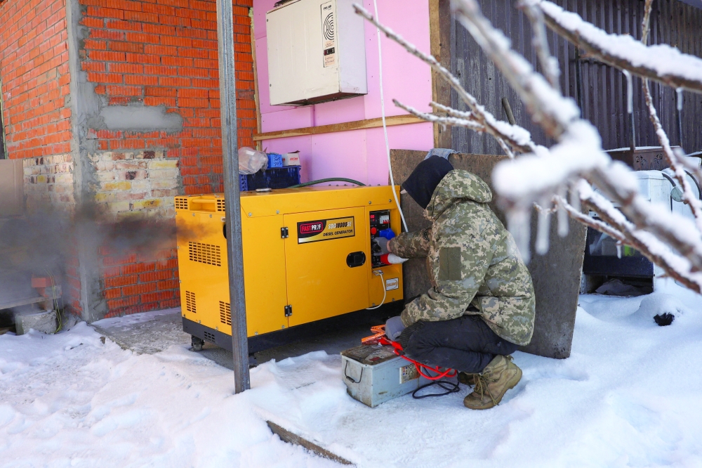 A worker starts a power generator in the town of Borodianka, Ukraine. — AFP