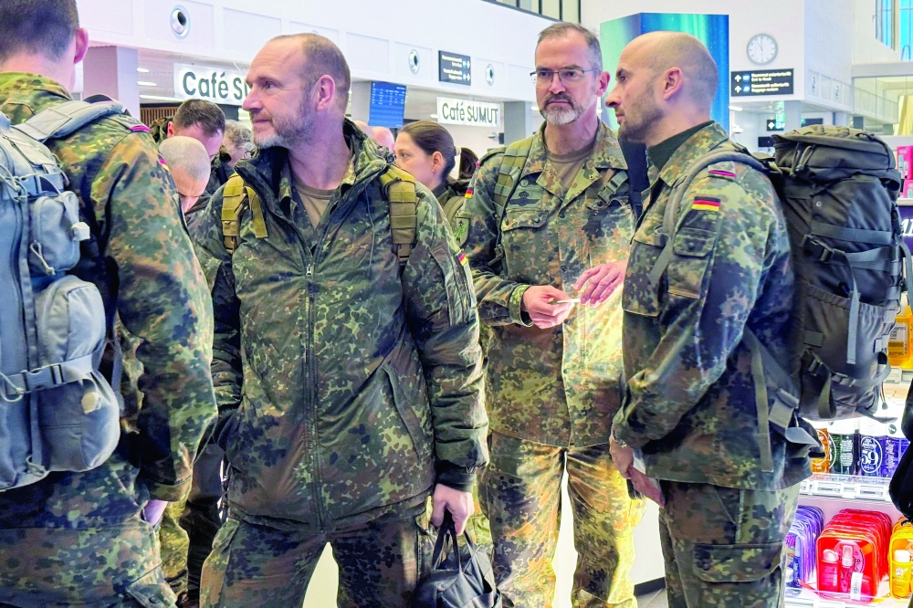 
Military personnel from the German Armed Forces Bundeswehr wait to board the Icelandair flight leaving Nuuk airport for Reykjavik on Sunday. — AFP 