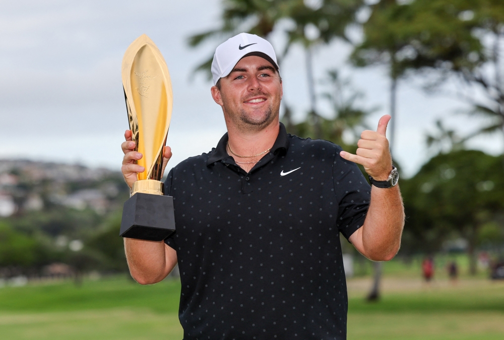 Chris Gotterup holds the championship trophy after winning the Sony Open 