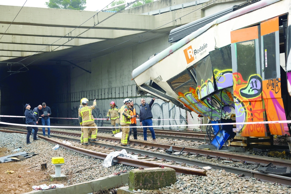 Police and firefighters inspect the scene of a commuter train derailment in Gelida on Wednesday. — Reuters