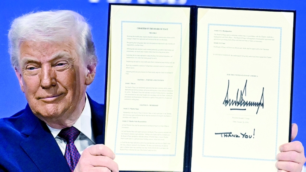 US President Donald Trump holds a signed founding charter at the "Board of Peace" in Davos on Thursday. — AFP