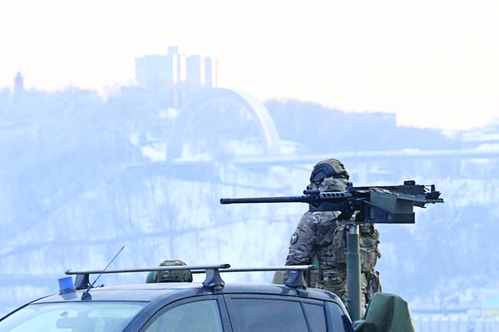 A Ukrainian serviceman stands next to a truck equipped with a machine gun during an air raid alert in Kyiv on Saturday. — AFP