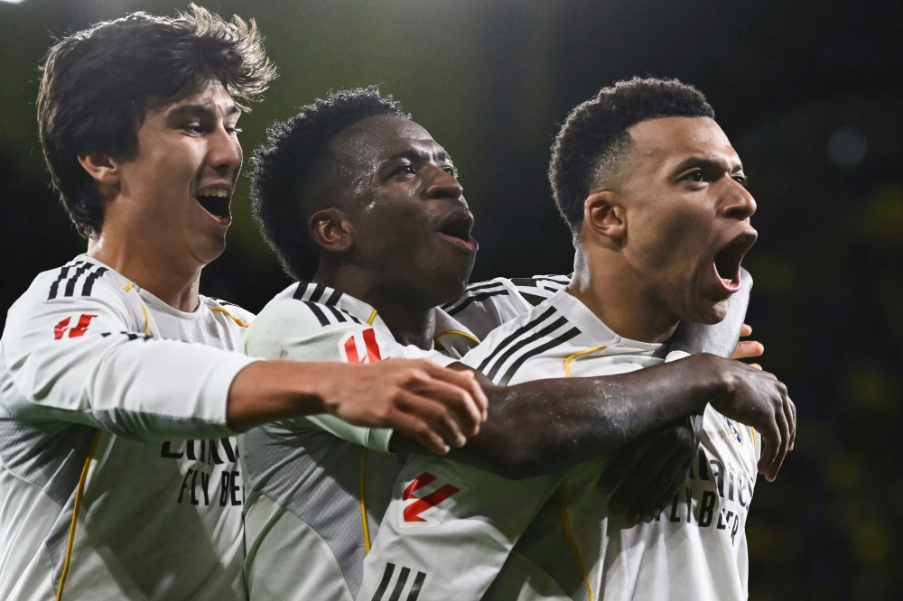 Real Madrid's Kylian Mbapp (R) celebrates with  Vinicius Junior (C) and Gonzalo Garcia 
