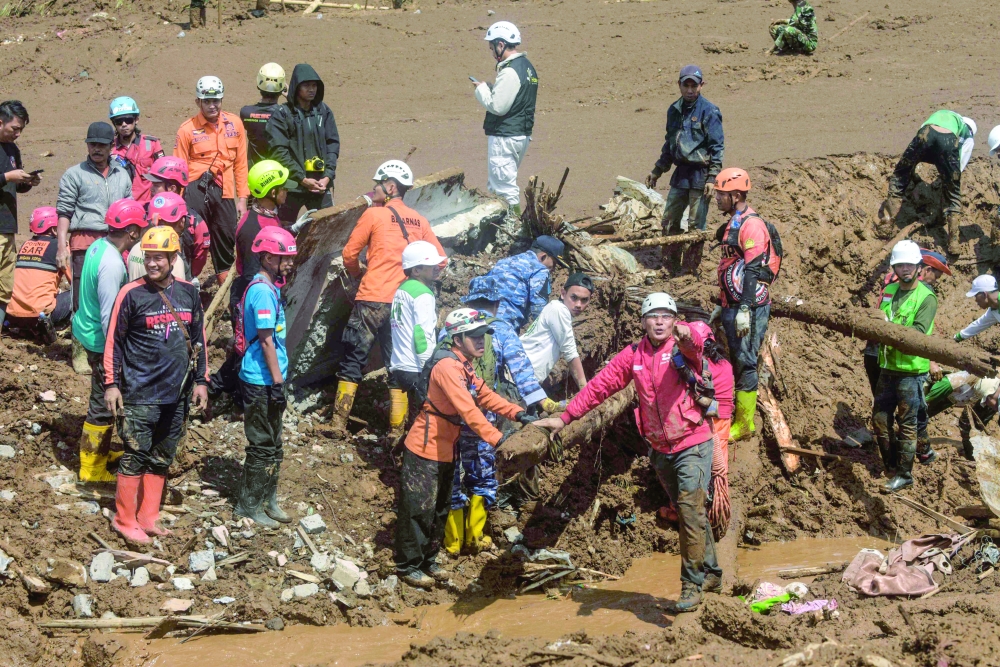 Rescuers search for landslide victims in Pasirlangu village, Bandung, West Java on January 25, 2026, after the disaster killed 16 people and left around 80 missing. (Photo by Timur Matahari / AFP)