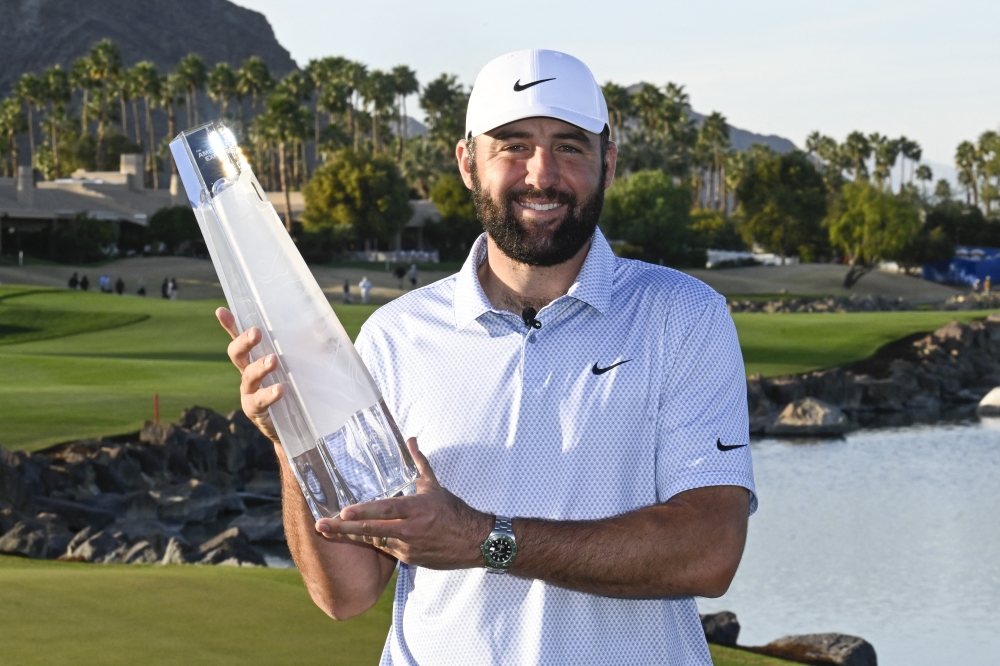   Scottie Scheffler lifts the American Express Trophy  