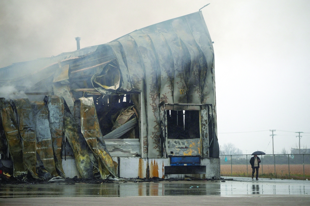 A person walks  at the premises of a biscuit factory, following a fire, near Trikala, Greece. — Reuters
