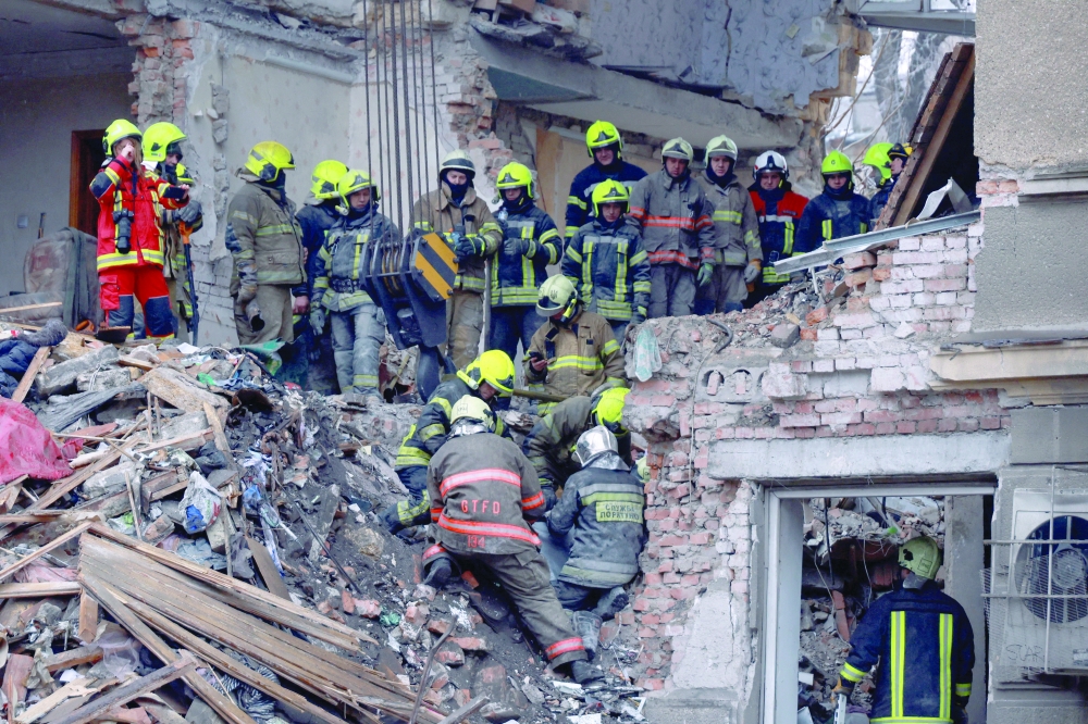 Rescuers place in a bag the body of a person found under debris in Odesa, Ukraine. — Reuters 
