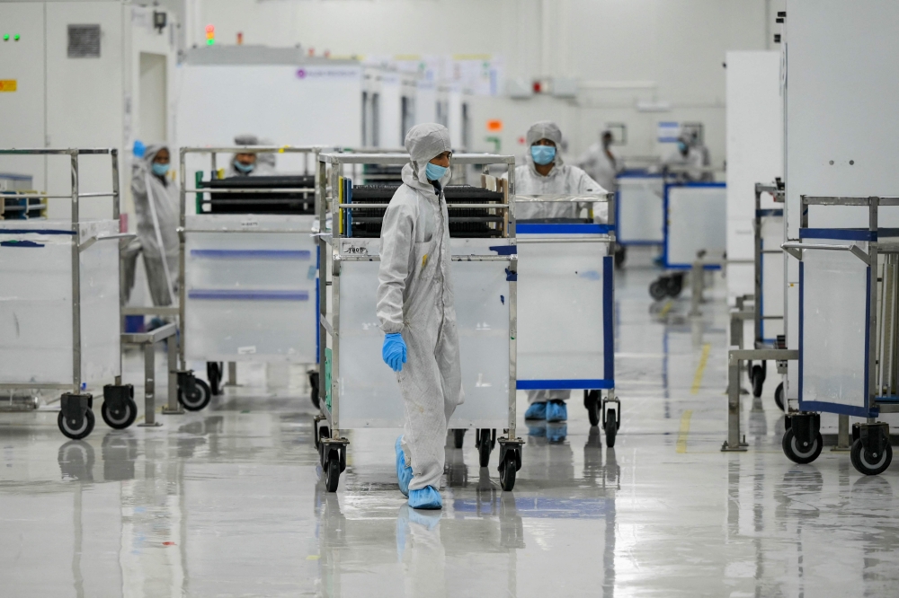 Employees in personal protective equipment (PPE) suits in Mundra, India.