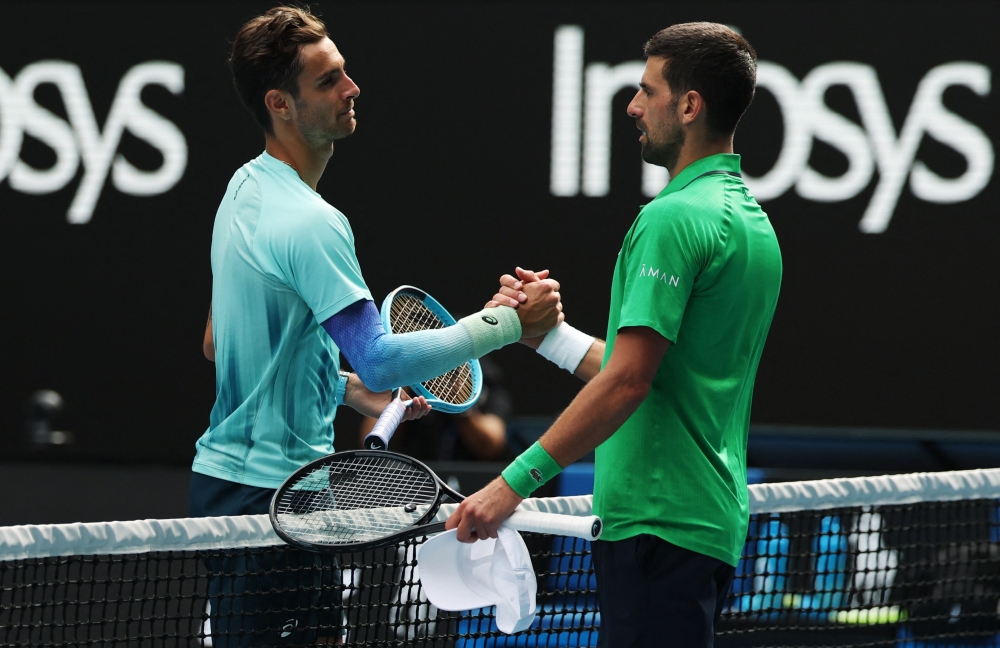 Italy's Lorenzo Musetti shakes hands with Serbia's Novak Djokovic after retiring from his quarter final match  