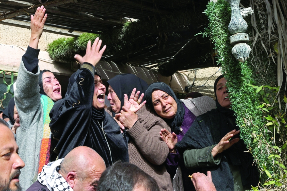 Mourners weep during a funeral of a Palestinian youth, killed by the Israeli forces, in the Al Dahriya village.  