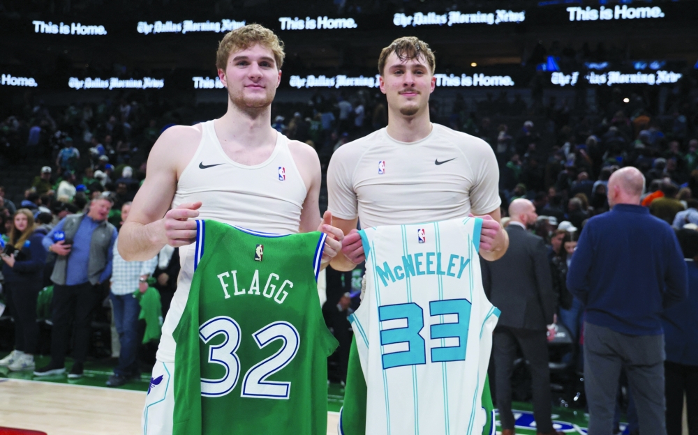 Dallas Mavericks forward Cooper Flagg (32) swaps jerseys with Charlotte Hornets guard Liam McNeeley (33) after the game at American Airlines Center 