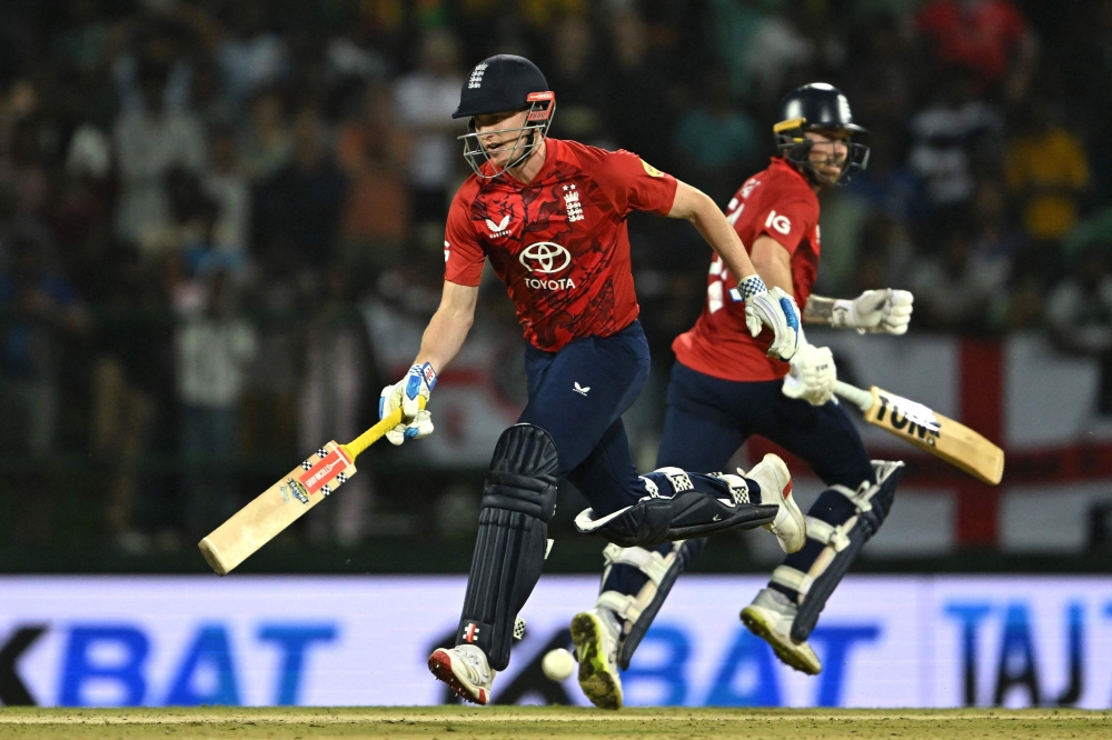 England's Phil Salt (R) and England's captain Harry Brook (R) run between the wickets