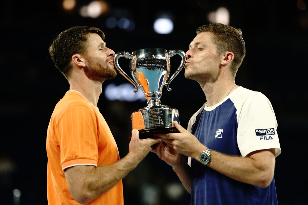  aHarrison and Neal Skupski kiss the trophy after winning their men's doubles final 
