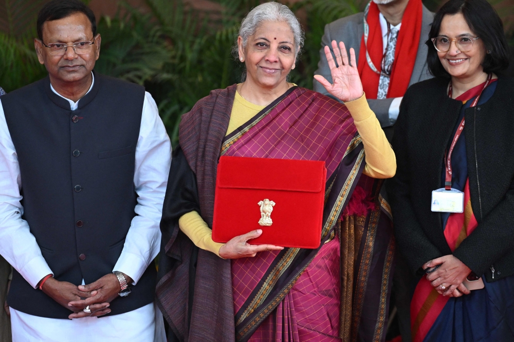 India's Finance Minister Nirmala Sitharaman (C) poses for photos before she leaves the Finance Ministry to present the annual budget to parliament at the Kartavya Bhavan in New Delhi on February 1, 2026.
