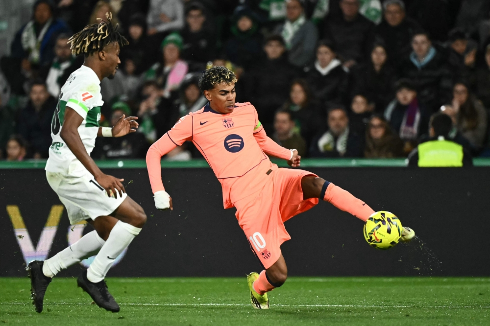  Elche's  #18 John Donald (L) and  #10 Lamine Yamal fight for the ball 