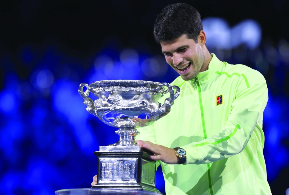 Carlos Alcaraz celebrates with the trophy after winning the Australian Open men's singles against Serbia's Novak Djokovic. Alcaraz becomes the youngest man to win all four grand slam titles. — Reuters