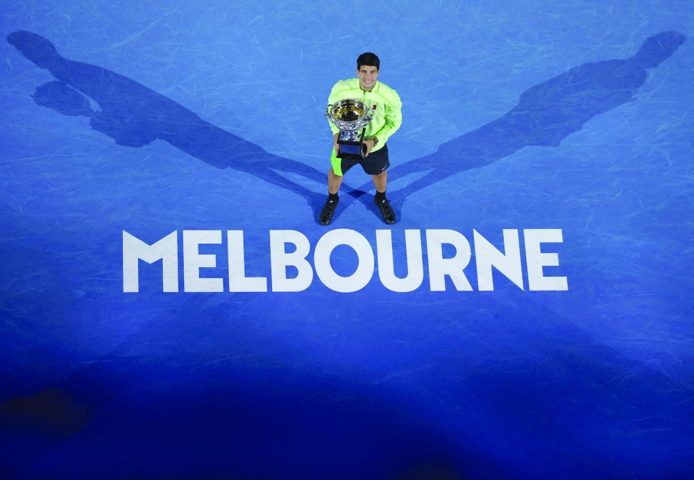 Carlos Alcaraz celebrates with the trophy after winning the Australian Open men's singles against Serbia's Novak Djokovic. Alcaraz becomes the youngest man to win all four grand slam titles. — Reuters