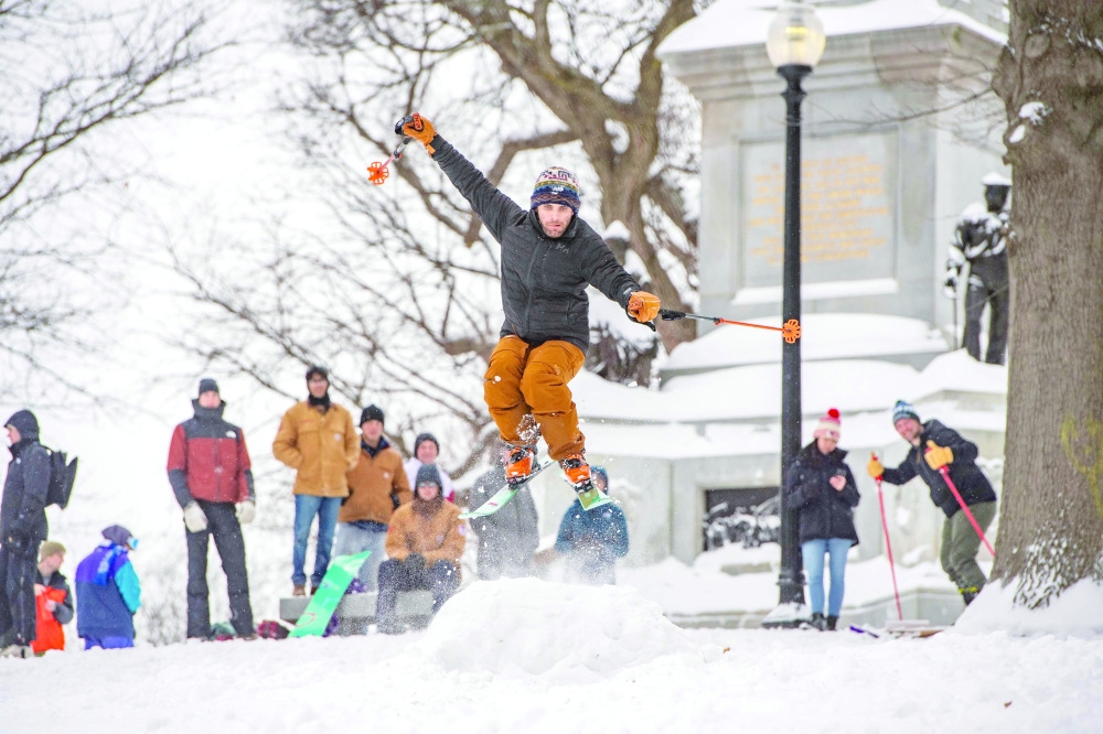 A skier gains air as he goes over a snow jump on Flagstaff Hill in Boston Common after a snowstorm in Boston. - AFP
