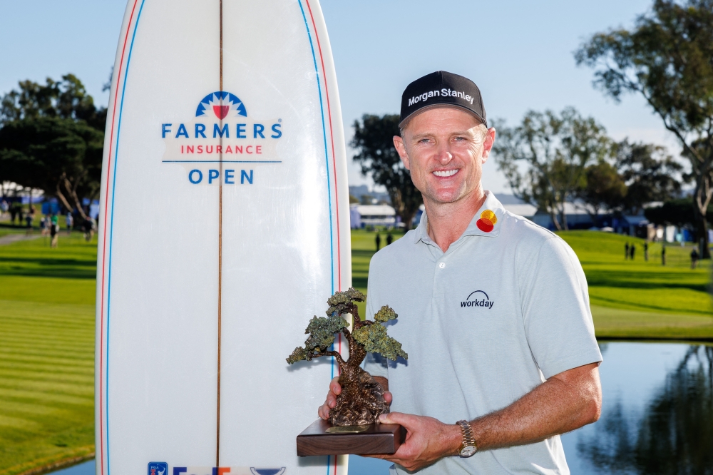 Justin Rose holds the Farmers Insurance trophy after the winning
