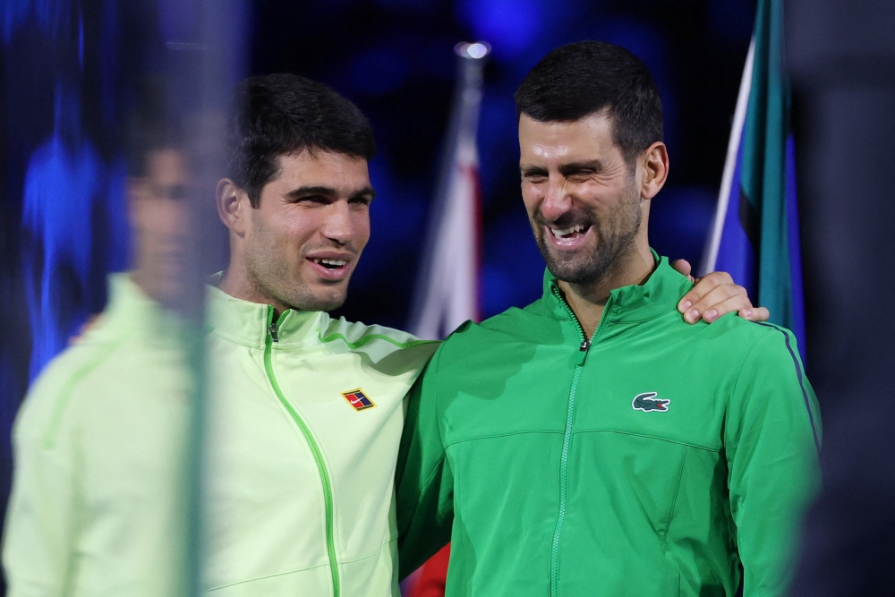 Spain's Carlos Alcaraz celebrates alongside Serbia's Novak Djokovic