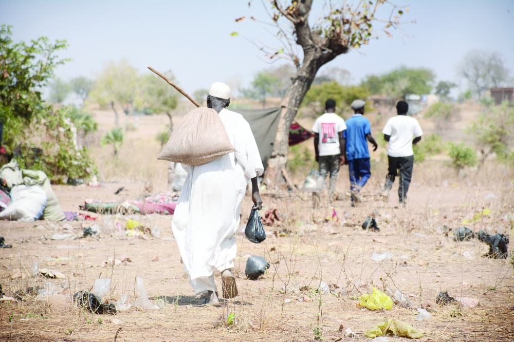 An elderly man picks up his food aid ration at the Umdulu Camp, in Engpung County, Sudan. — AFP