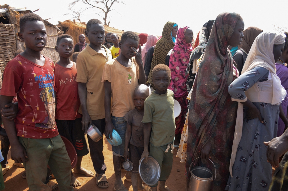 Displaced people queue to receive meals at Thobo Camp, in Engpung County. — Reuters
