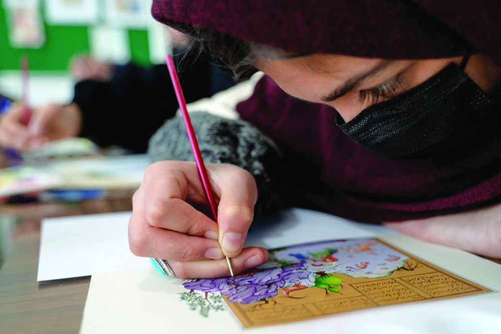 An Afghan woman painting miniature art at a workshop in Herat