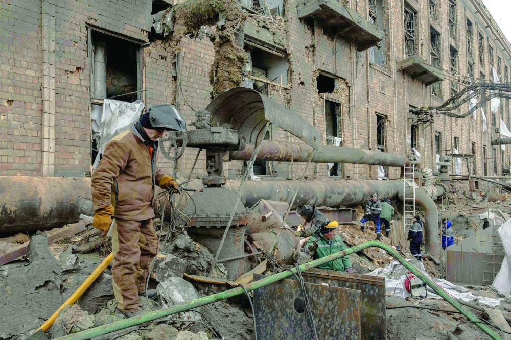 Employees repair sections of the Darnytska combined heat and power plant damaged by Russian air strikes in Kyiv on  Wednesday. 