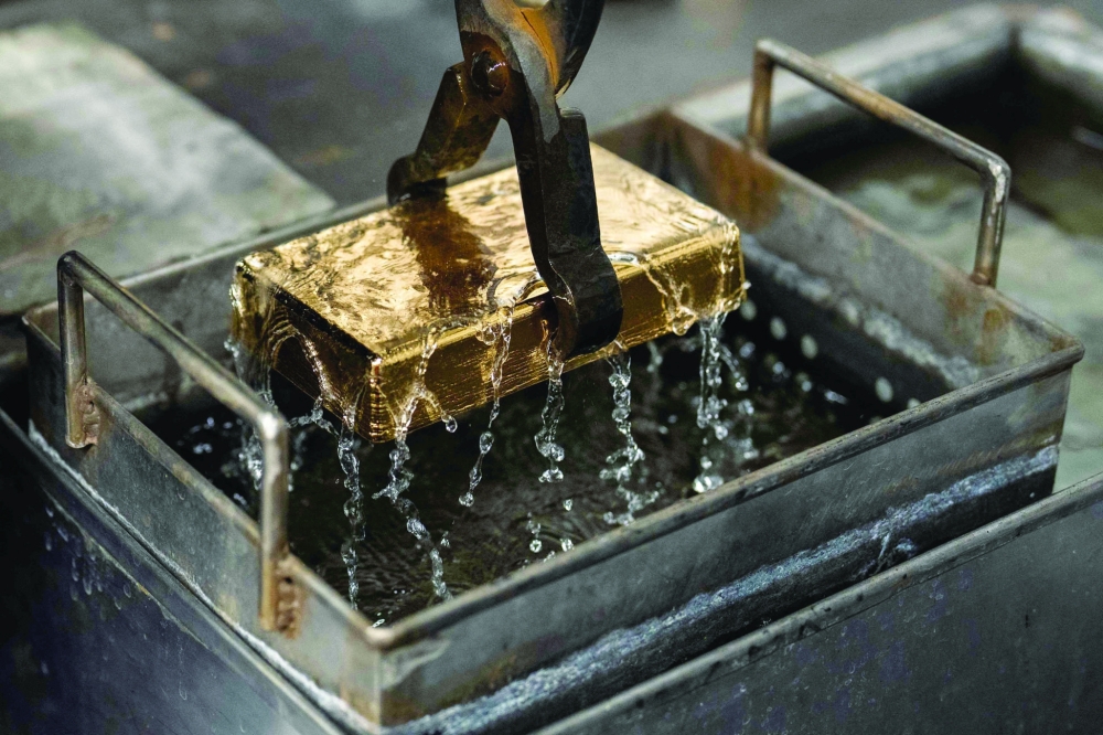 A gold bar is cooled in water after being molded at the Austrian Gold and Silver Refinery (Oegussa) in Vienna, Austria, on February 3, 2026. European and Asian stock markets struggled for direction February 4, 2026 following a tech-fuelled sell-off on Wall Street, while precious metals recovered further. - Austria OUT (Photo by GEORG HOCHMUTH / APA / AFP)