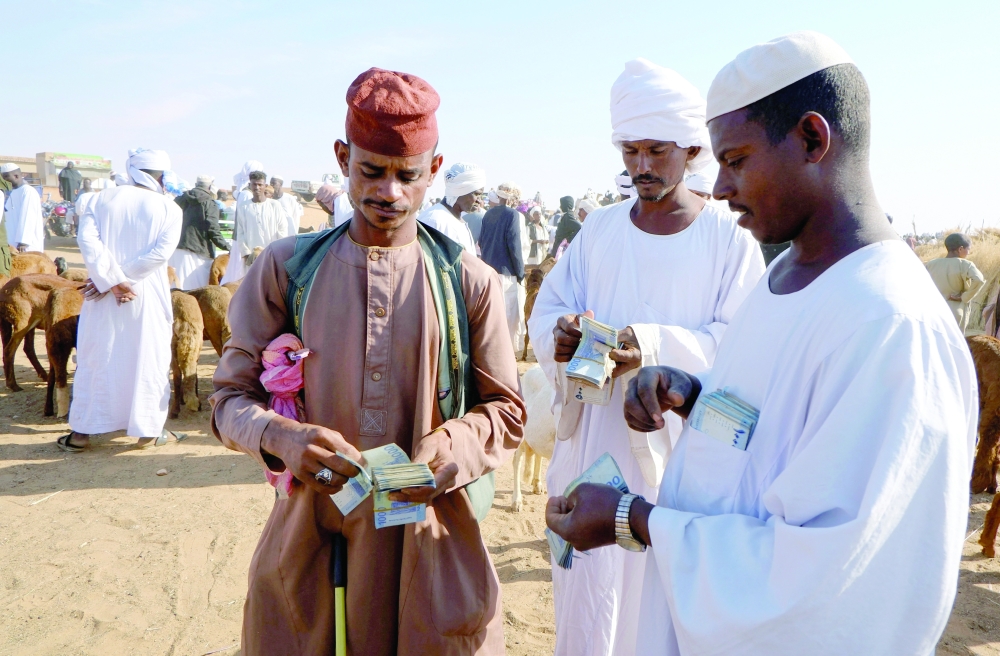 Livestock traders count money after completing a sale at the livestock export market, in El Obeid, North Kordofan State, Sudan. - Reuters