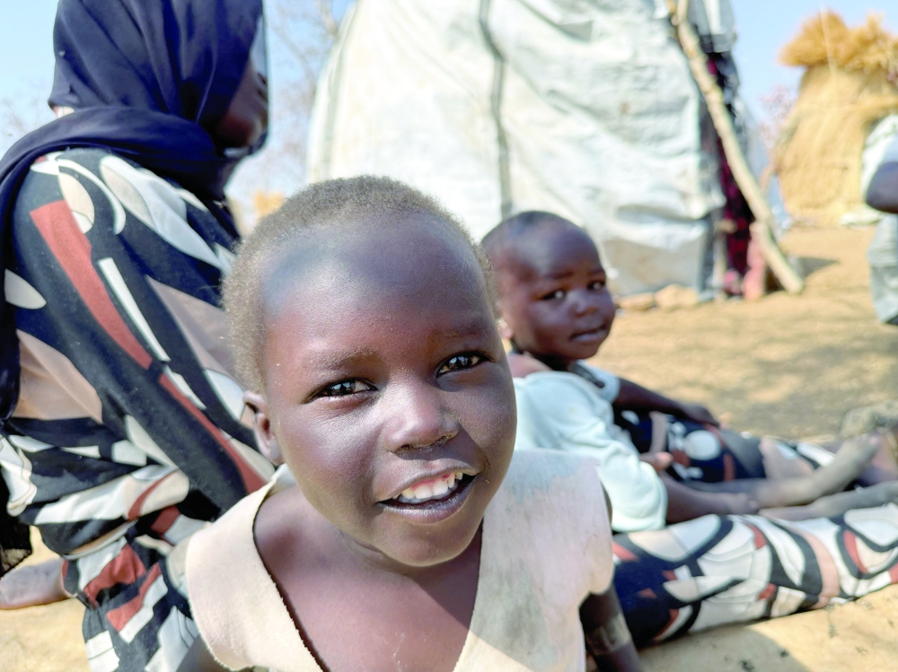 A boy reacts as he sits with his family, displaced from Kadugli, at Embal Camp in Engpung County, Sudan. - Reuters 