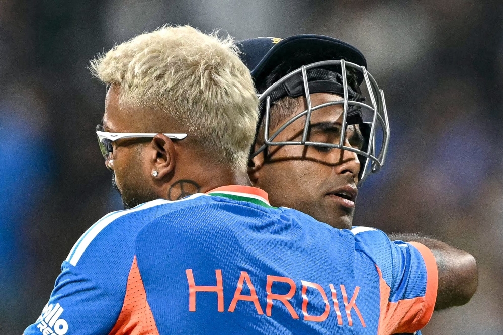 India's captain Suryakumar Yadav (R) is being hugged by his teammate Hardik Pandya at the end of Indian inning  