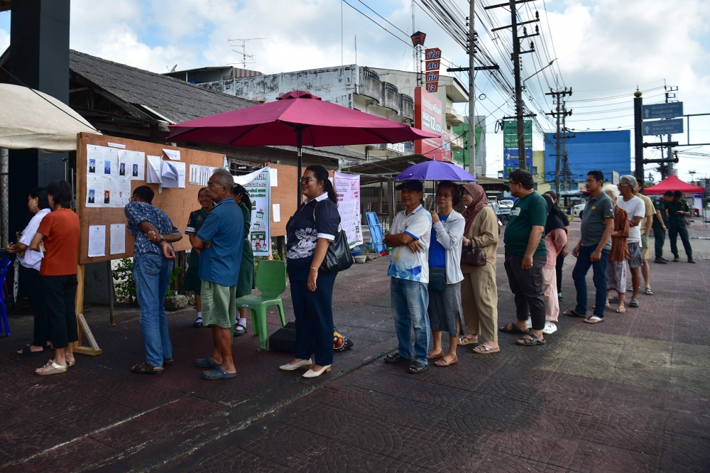 Voters line up to cast their ballots at a polling station in southern Thailand's Narathiwat. — AFP