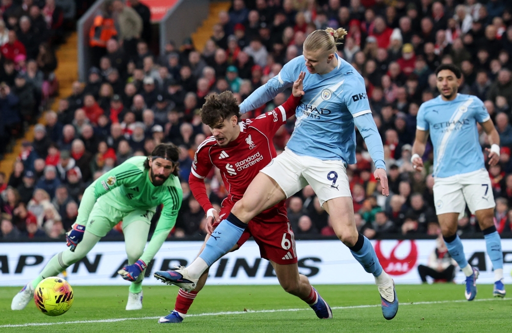   Liverpool's Milos Kerkez in action with Manchester City's Erling Haaland   