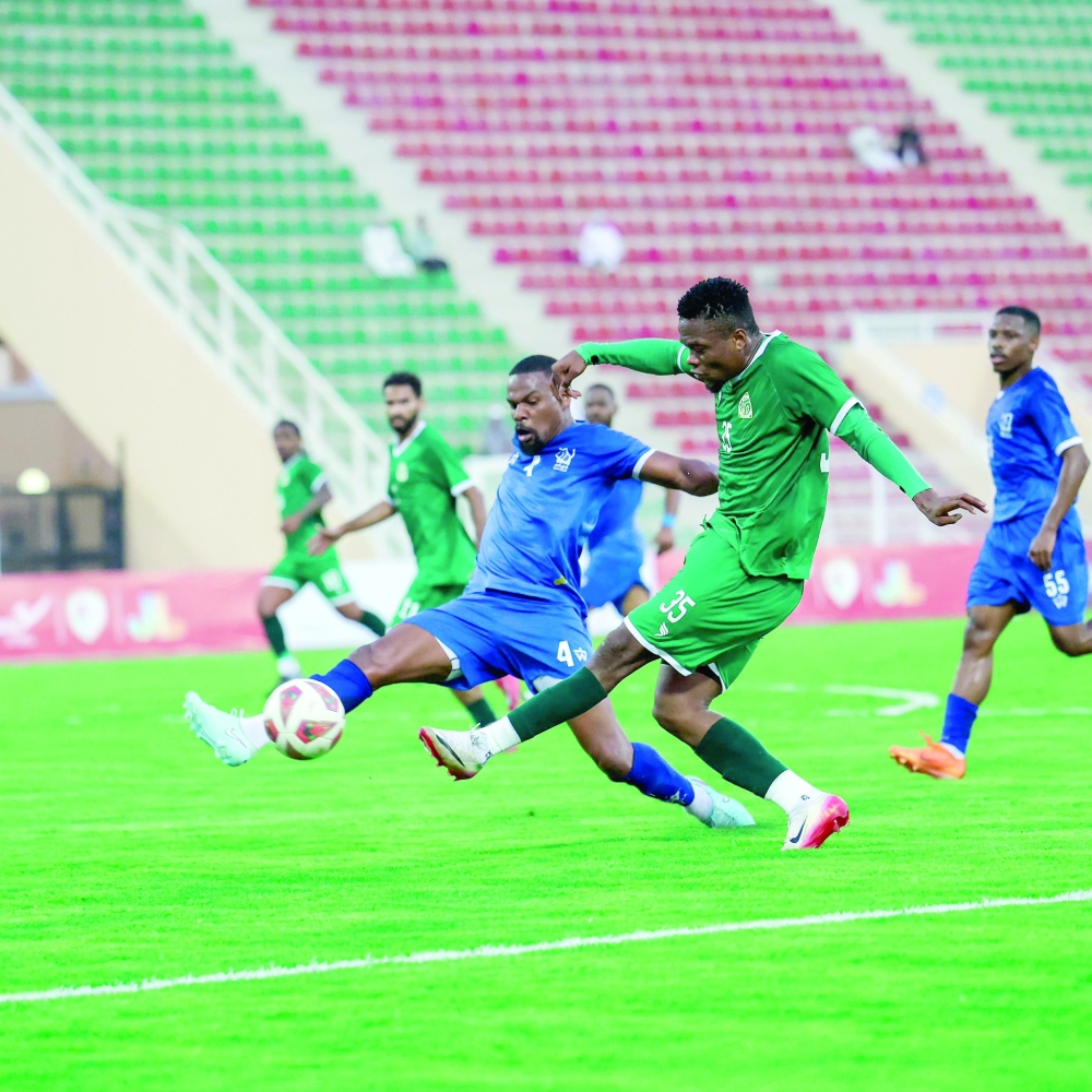 Sohar player makes a shot challenged by Sur player.