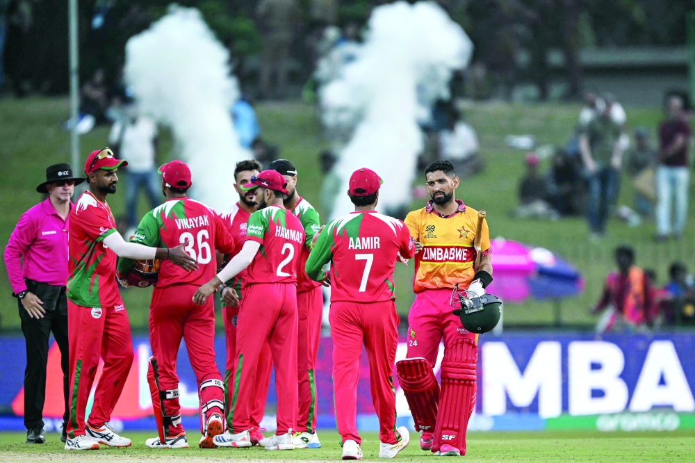 Zimbabwe's captain Sikandar Raza (R) shakes hands with Oman's players at the end of the 2026 ICC Men's T20 Cricket World Cup group stage match between Zimbabwe and Oman at the Sinhalese Sports Club Ground in Colombo on February 9, 2026.  (Photo by Ishara S. KODIKARA / AFP)
