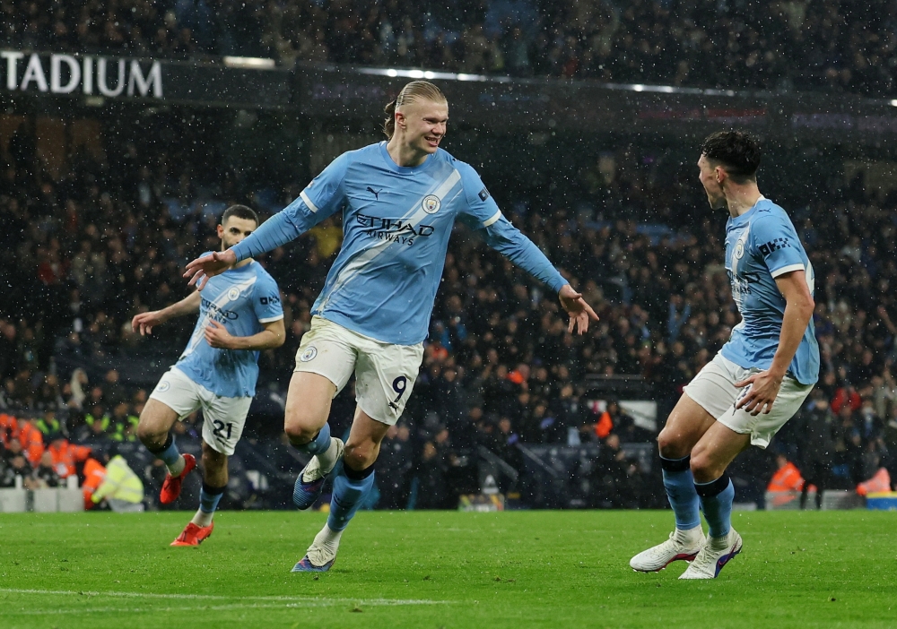   Manchester City's Erling Haaland celebrates scoring their third goal with Phil Foden  