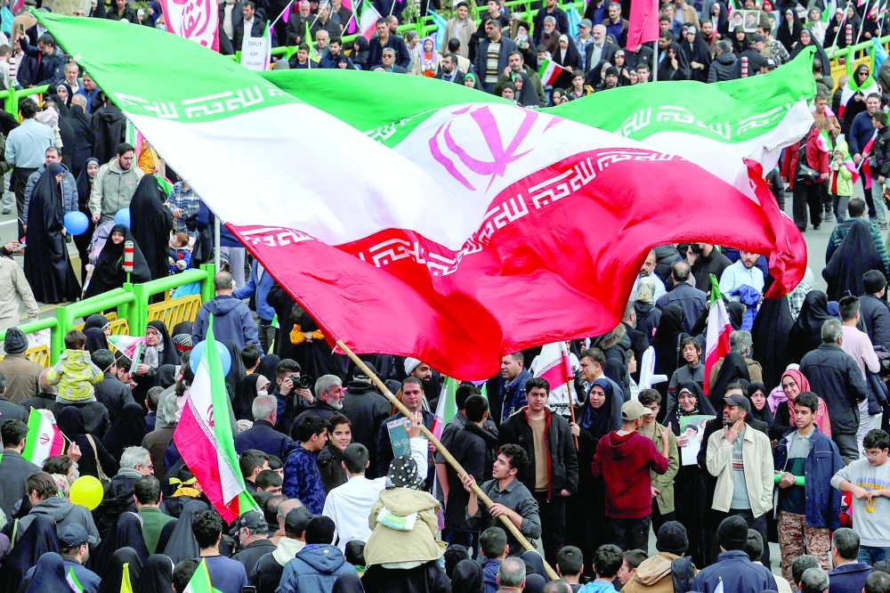 A man waves a giant Iranian flag during a rally marking the 47th anniversary of the 1979 Islamic revolution in Tehran on Thursday. — AFP