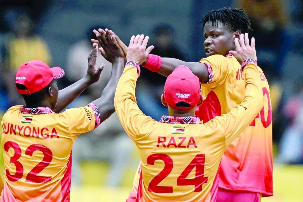 Zimbabwe's Blessing Muzarabani (R) celebrates with teammates