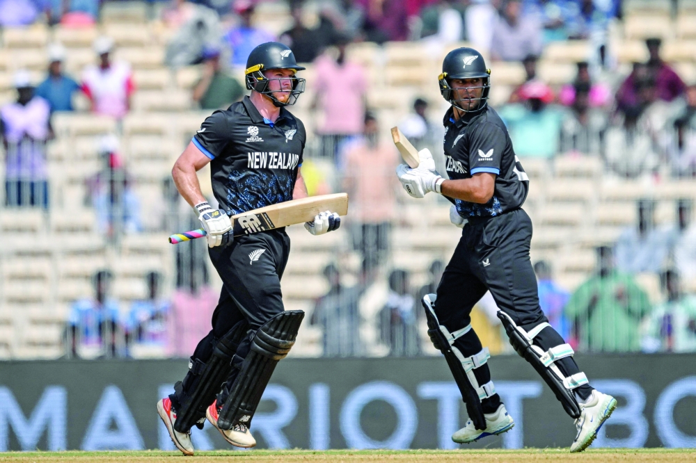New Zealand's Glenn Phillips (L) and Rachin Ravindra run between the wickets during the 2026 ICC Men's T20 Cricket World Cup group stage match between Canada and New Zealand at the MA Chidambaram Stadium in Chennai on February 17, 2026.  (Photo by R. Satish BABU / AFP)
