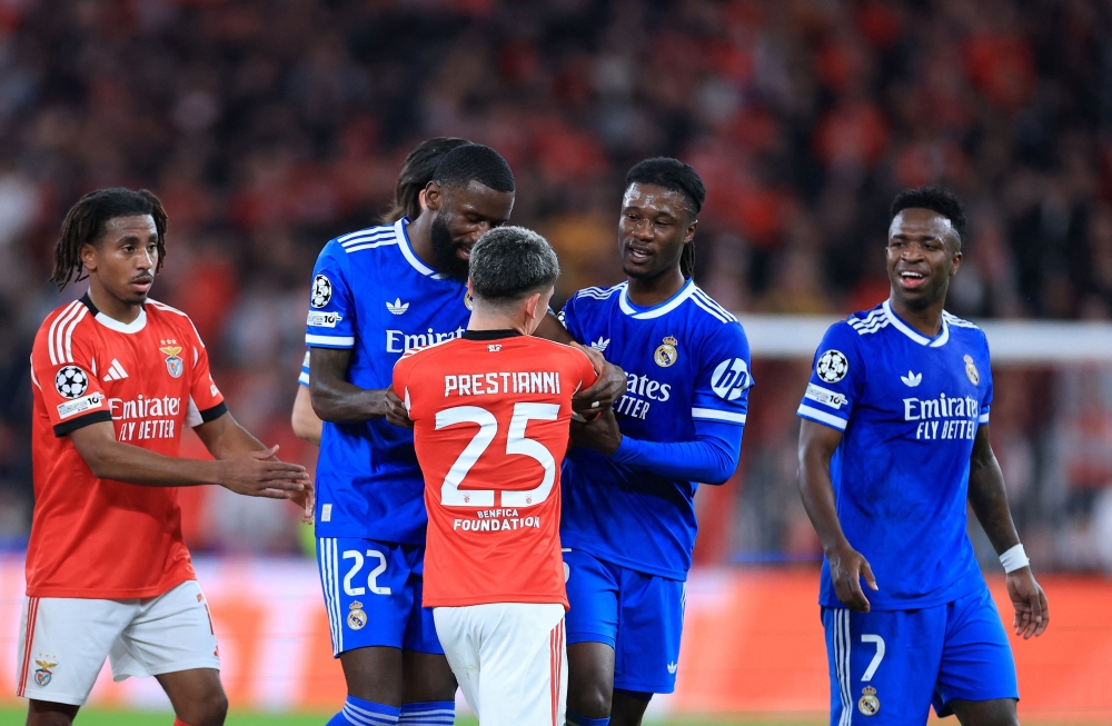 SL Benfica's Argentine forward #25 Gianluca Prestianni argues with Real Madrid's Brazilian forward #07 Vinicius Junior (R)  
